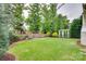 Spacious backyard featuring lush green grass, mature trees, and a charming playhouse at 724 Lagan Ct, Fort Mill, SC 29715