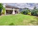 Spacious backyard featuring a covered patio, large grassy area, and mature trees at 724 Lagan Ct, Fort Mill, SC 29715