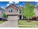 Charming two-story home featuring a two-car garage, manicured lawn, and beautifully landscaped front yard at 724 Lagan Ct, Fort Mill, SC 29715