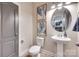 Powder room featuring a pedestal sink, round mirror, and blue botanical artwork at 724 Lagan Ct, Fort Mill, SC 29715