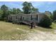 Ranch-style home with beige siding, red shutters, front ramp, and a well-maintained lawn at 7494 Flat Creek Rd, Lancaster, SC 29720
