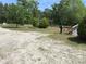Expansive front yard with mature trees and landscaping, showcasing the property's natural beauty and curb appeal at 7494 Flat Creek Rd, Lancaster, SC 29720