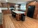 Bright kitchen featuring custom wood cabinets, a large island, and modern black appliances at 7494 Flat Creek Rd, Lancaster, SC 29720