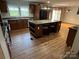 A well-lit kitchen featuring an island with seating, wooden cabinets, and views of the outdoor greenery at 7494 Flat Creek Rd, Lancaster, SC 29720