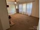 Inviting living room with large windows, neutral carpet, and a partial view of the stone fireplace at 7494 Flat Creek Rd, Lancaster, SC 29720
