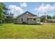View of the side of home showcasing gray siding, fenced yard, and a neat, well-maintained lawn at 842 Murphy St, Kannapolis, NC 28081