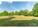 Expansive backyard highlighting mature trees, lush grass, and a trampoline at 945 Songbird St, Lancaster, SC 29720