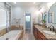 Bright bathroom featuring granite countertops, double sinks, a tub, and an adjacent toilet room at 945 Songbird St, Lancaster, SC 29720