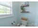 Toilet in bathroom with a window and shelves for toilet paper and plants at 945 Songbird St, Lancaster, SC 29720
