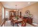 Formal dining room with a large wooden table, elegant chairs, a decorative hutch, and a stylish chandelier at 945 Songbird St, Lancaster, SC 29720