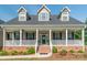 Inviting front porch with a white railing, brick base, and a beautifully decorated front door and curb appeal at 945 Songbird St, Lancaster, SC 29720