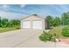 Two-car garage features white doors and ample parking space, set against a backdrop of mature trees and blue sky at 945 Songbird St, Lancaster, SC 29720