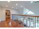 Upstairs hallway with hardwood floors and iron railing overlooking the living room below at 945 Songbird St, Lancaster, SC 29720