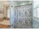 Floral shower curtain hanging in the bathroom with a shower and tub at 945 Songbird St, Lancaster, SC 29720