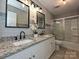 Bathroom featuring a dual sink granite vanity, modern fixtures, and a shower with sliding glass doors at 9565 Man O War Rd, Indian Land, SC 29707