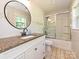 Bathroom with a granite countertop, white cabinets, round mirror, and shower with sliding glass doors at 9565 Man O War Rd, Indian Land, SC 29707