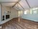 Inviting living room boasts vaulted ceilings, a brick fireplace, and hardwood floors at 9565 Man O War Rd, Indian Land, SC 29707