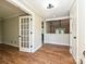 Spacious living room with hardwood floors, white trim, and French doors leading to another room at 9565 Man O War Rd, Indian Land, SC 29707