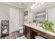 Well-lit bathroom featuring double sinks, wood cabinets, and decorative accents at 10011 Spring Park Dr, Charlotte, NC 28269