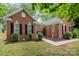 Attractive red brick home featuring manicured landscaping, and a welcoming walkway to the front door at 10011 Spring Park Dr, Charlotte, NC 28269