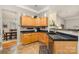Bright kitchen with natural wood cabinets, black countertops, and tile floors at 10011 Spring Park Dr, Charlotte, NC 28269