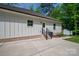 Exterior view of the home featuring white siding, a brick foundation, and a concrete patio area at 1012 W Carroll St, Cherryville, NC 28021
