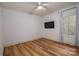 Bedroom with light wood floors, neutral walls, TV and a window with white curtains at 1012 W Carroll St, Cherryville, NC 28021