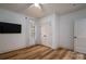 Bedroom with light wood floors, neutral walls, TV and a window with white curtains at 1012 W Carroll St, Cherryville, NC 28021