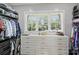 Organized walk-in closet featuring custom white drawers and shelving, offering ample storage and bright natural light at 106 Thunder Hill Rd, Mooresville, NC 28117