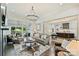 Open-concept living room with modern chandelier, hardwood floors, and seamless connection to the kitchen and outdoor areas at 106 Thunder Hill Rd, Mooresville, NC 28117