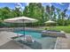 Beautiful backyard pool with lounge chairs, umbrellas, and a well-manicured lawn at 106 Thunder Hill Rd, Mooresville, NC 28117