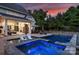 Backyard with a luxurious pool, integrated hot tub, outdoor fireplace, and lounge seating for ultimate relaxation at 106 Thunder Hill Rd, Mooresville, NC 28117