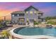 Expansive backyard featuring a large in-ground pool, patio seating, and a well-maintained lawn at sunset at 1098 Matchstick Sw Pl, Concord, NC 28025