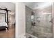 Spa-like bathroom featuring a tiled walk-in shower with glass door and a view of the bedroom at 1098 Matchstick Sw Pl, Concord, NC 28025