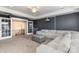 Well-lit bonus room featuring a large sectional sofa, ottoman, and gray walls with white trim at 1098 Matchstick Sw Pl, Concord, NC 28025