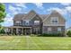 Impressive two-story home with a stone facade, well-manicured lawn, and inviting front porch at 1098 Matchstick Sw Pl, Concord, NC 28025