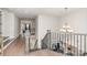 Hallway featuring hardwood floors, staircase with iron railing, and a decorative chandelier at 1098 Matchstick Sw Pl, Concord, NC 28025