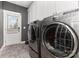 Well-equipped laundry room with modern washer and dryer, ample storage cabinets, and tile flooring at 1098 Matchstick Sw Pl, Concord, NC 28025