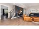 Cozy living area featuring hardwood floors, staircase access, and a stylish accent wall at 1098 Matchstick Sw Pl, Concord, NC 28025