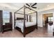 Elegant main bedroom featuring a wooden canopy bed, hardwood floors, and plenty of natural light at 1098 Matchstick Sw Pl, Concord, NC 28025