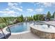 An outdoor pool and hot tub with lush landscaping, lounge chairs, and plenty of room to relax at 1098 Matchstick Sw Pl, Concord, NC 28025