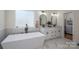 Spa-like bathroom featuring a soaking tub, dual vanities, and designer finishes at 115 Woodward Way, Iron Station, NC 28080