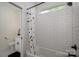 This bathroom features a tiled shower/tub with a patterned curtain, a window and a dark floor mat at 115 Woodward Way, Iron Station, NC 28080