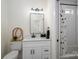 This bathroom features white cabinets, modern fixtures, and a shower/tub combo with patterned curtains at 115 Woodward Way, Iron Station, NC 28080