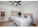Cozy bedroom featuring a ceiling fan, dresser with mirror, and comfortable bed with stylish bedding and a view to the bathroom at 115 Woodward Way, Iron Station, NC 28080