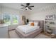 This bedroom features a ceiling fan, a large window, and playful decor at 115 Woodward Way, Iron Station, NC 28080