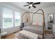 This bedroom features a brass canopy bed, a sitting bench, and a large window at 115 Woodward Way, Iron Station, NC 28080