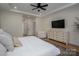 Well-lit bedroom with neutral tones, modern ceiling fan, and access to hall at 115 Woodward Way, Iron Station, NC 28080