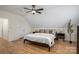 This bedroom features a ceiling fan, wood floors, and a sloped ceiling at 115 Woodward Way, Iron Station, NC 28080