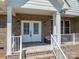 Inviting front porch features a brick facade, seating, and double door entry at 115 Woodward Way, Iron Station, NC 28080